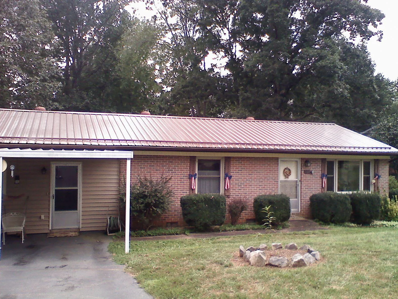 Bronze metal roof and carport on a brick ranch home — Roof Repair work by our crew in Malden